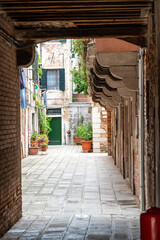 Quiet Venetian Alleyway with Overhanging Architecture in Italy