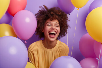 Obraz premium Laughing Young Woman Surrounded by Colorful Balloons with Copy Space