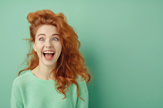 Laughing Redhead Woman in Green Sweater on Turquoise Background
