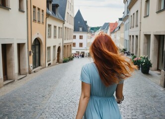 Rear view of a happy female traveller running in the streets of Luxembourg.