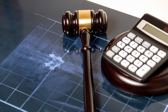 Image showcasing a judge's gavel and calculator on top of a radiographic film, suggesting medical billing or legal issues in healthcare.