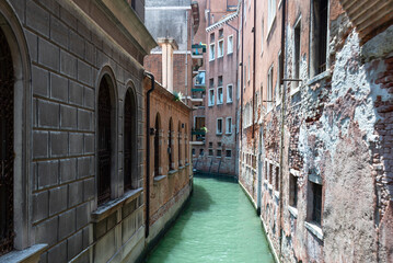 Narrow Venetian Canal Between Aged Buildings in Italy