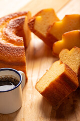 Orange cake and cup of coffee, beautiful orange cake and a cup of coffee and accessories on rustic wooden surface, dark background, selective focus.