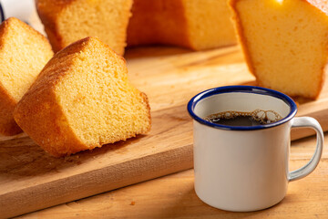 Orange cake and cup of coffee, beautiful orange cake and a cup of coffee and accessories on rustic wooden surface, dark background, selective focus.