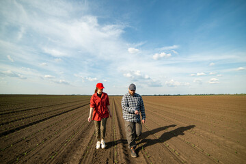 Young farmers examing planted young corn