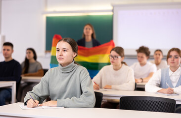 Teacher explaining meaning of LGBT flag to students in school