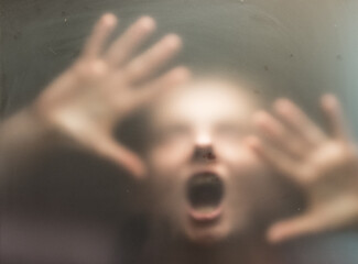 Scary picture of hands behind glass.