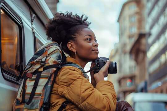 Young black female tourist taking pictures of the city with her camera