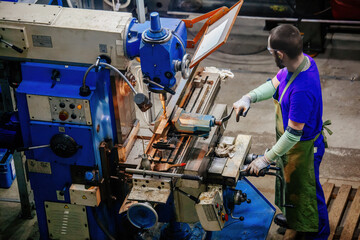 Industrial worker operating drilling machine