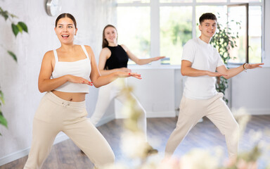 Fototapeta premium Group of young women and young guy rehearsing jazz funk dance in dance studio