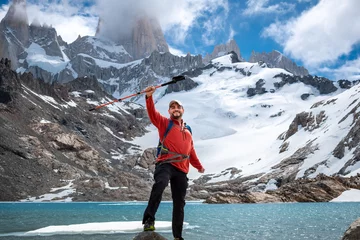 Papier Peint photo autocollant Fitz Roy Caminante alzando su bastón en señal de triunfo por subir hasta la Laguna de Los Tres, en el Chalten, Patagonia