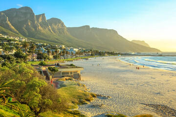 White long and spectacular beach of Camps Bay with Table Mountain National Park behind him in Cape Town, South Africa, Atlantic Ocean view. Shot taken at sunset.