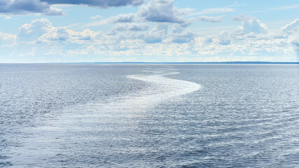 Republic of Karelia, Russia, Lake Ladoga, Panoramic view of the lake surface during calm, mirrored water with wake trail, cloudy sky, at daytime