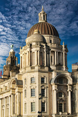 Fototapeta premium Majestic baroque building with a large dome under a blue sky with fluffy clouds in Liverpool, UK.