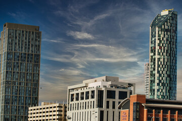 Modern cityscape with skyscrapers against a blue sky with wispy clouds in Liverpool, UK.