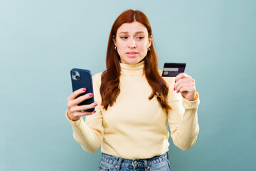 Upset redhead woman having problems with her credit card and online shopping