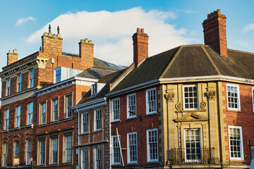 Historic brick buildings with classic British architecture under a clear blue sky in York, UK.