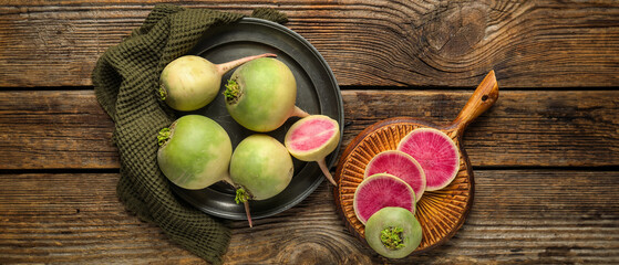 Tray and board with ripe watermelon radishes on wooden background