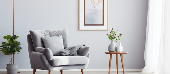Grey armchair near bed with poster in bedroom interior with window and rug.
