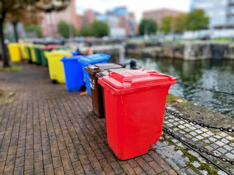 Red garbage bin with other bins
