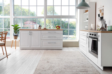 Interior of kitchen with white counters and oven