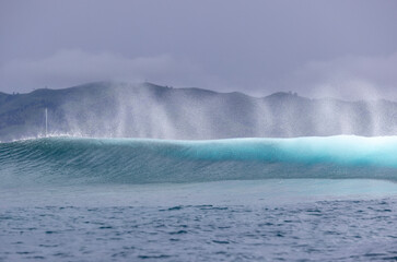 Naklejka premium Ocean wave spray from behind a wave