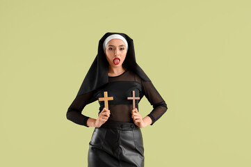 Sexy nun with crosses showing tongue on green background