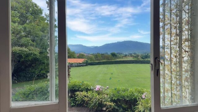 Open window to the summer garden in the village with flowers and butterflies. Summer landscape. Good morning. View from the house