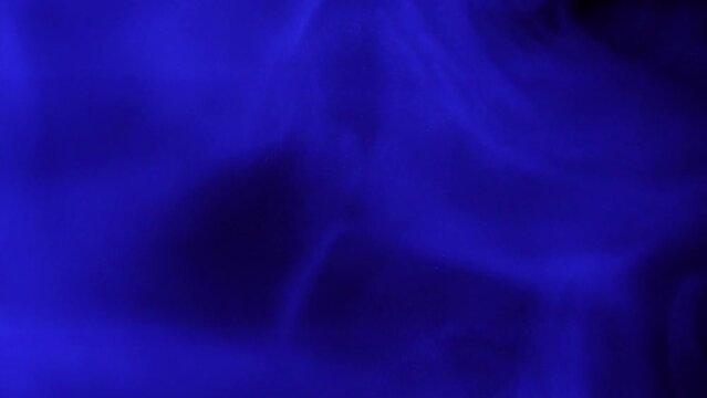 Dynamic blue smoke moves with fluidity against a dark background 4K footage.
