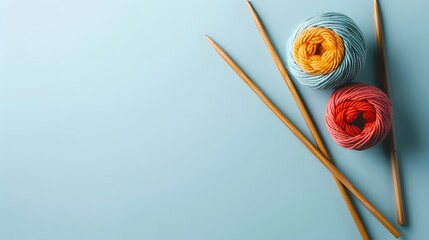 Three balls of thread and wooden bamboo knitting needles on light blue background. Hobby, relaxation, mental health, sustainable lifestyle