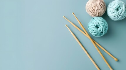 Three balls of thread and wooden bamboo knitting needles on light blue background. Hobby, relaxation, mental health, sustainable lifestyle