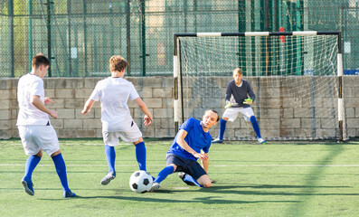 Fototapeta premium Teens playing soccer football match. Competition between two youth soccer teams. Football soccer tournament