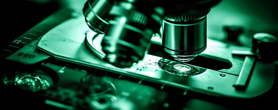 Microscope with metal lens at laboratory. Scientific and healthcare research, examining of test sample in a lab. Medical equipment. Science and technology concept