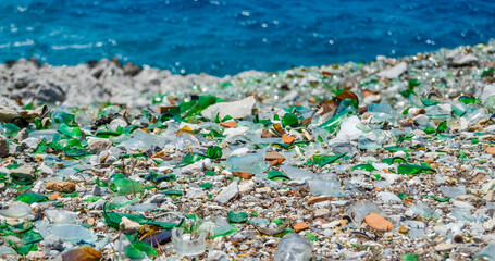 The beach is strewn with glass fragments and metal debris.