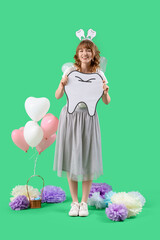 Tooth Fairy with paper figure and balloons on green background