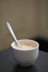 Cup of coffee or chai with spoon on table