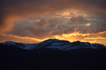 Sun Glowing Through the Clouds at Sunset Over the Rocky Mountains