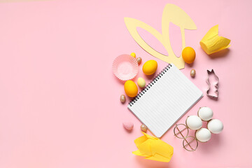 Blank notepad for recipes with bunny ears, Easter eggs and baking molds on pink background