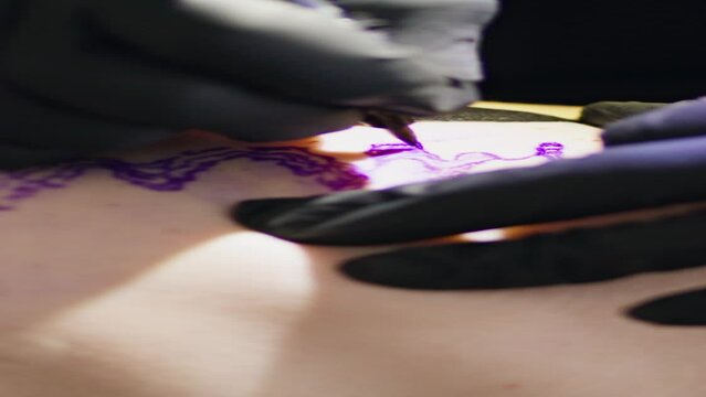 Master hands drawing tattoo at studio vertical closeup. Unknown artist use tool