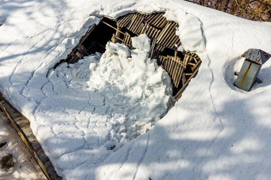 The roof of a building collapsed under the weight of snow, view from a drone
