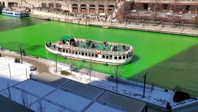Dynamic HD video footage of the Chicago Green dyed green for Saint Patrick's Day with boats on the river and the skyline on a sunny day in March.