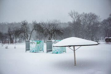 Beach with umbrella and cabanas during heavy snowfall in winter