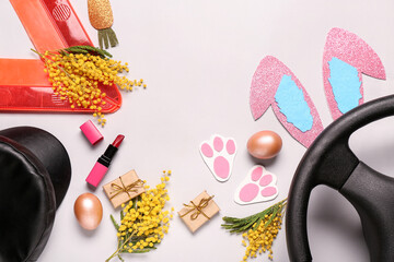 Composition with warning triangle, steering wheel, lipstick and Easter decor on grey background