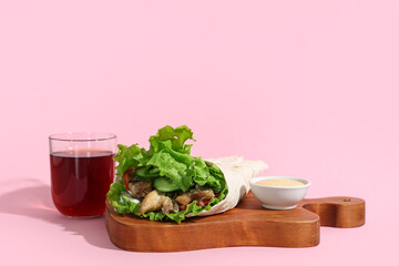 Board with tasty doner kebab on pink background