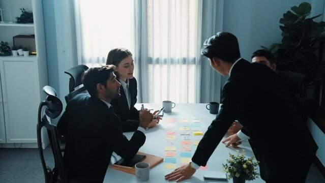 Top view of business team discuss about marketing strategy while smart manager enter meeting and talking about plan. Diverse people brainstorming idea by using sticky notes at board room. Directorate.