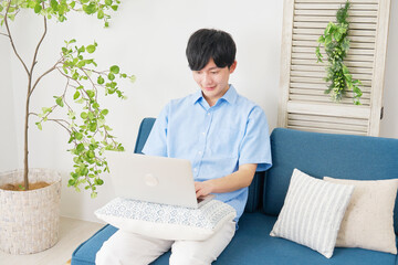 リビングルームでノートパソコンを使う若い男性