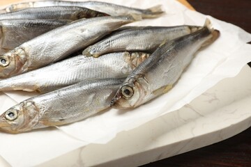 Fresh raw sprats on wooden table, closeup