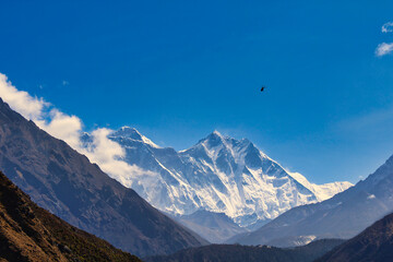 A helicopter heads to the Everest base camp and can be seen against the towering Everest and Lhotse...