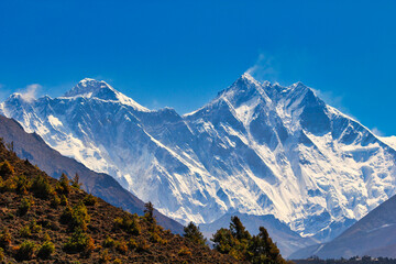 Mount Everest, Nuptse jagged ridge and Lhotse summit towers over the alpine landscape visible in this telephoto shot from Namche Bazaar in Khumbu, Nepal
