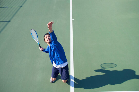 サーブを振りかぶる男性